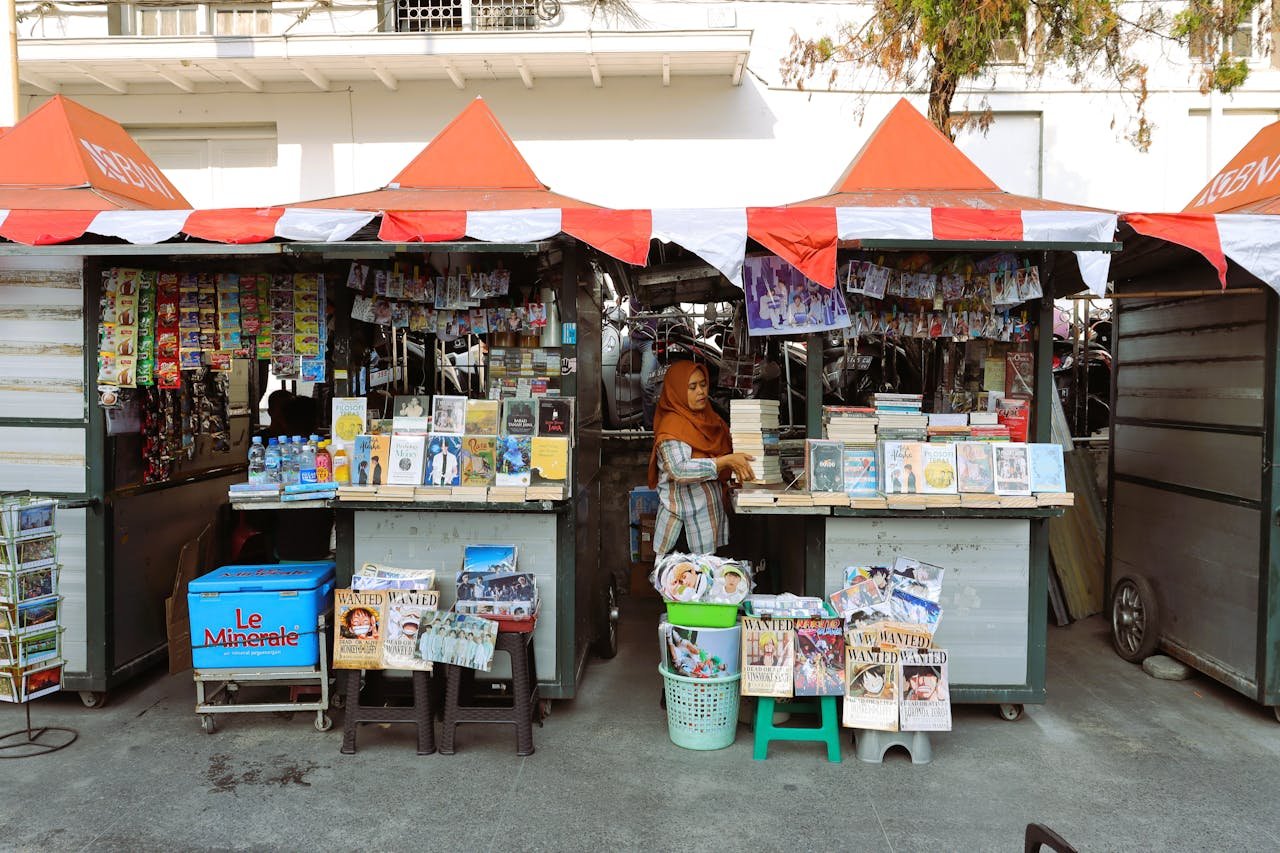 Street bookstall selling popular novels and bottled drinks in Indonesia